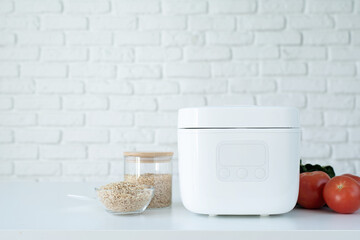 Electric rice cooker on wooden counter-top in the kitchen