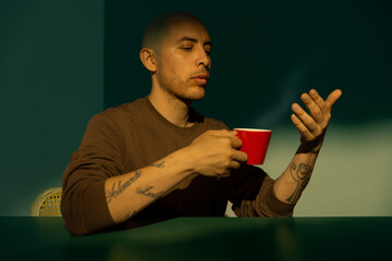 man with a red coffee cup at a table