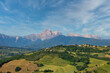 Panoramaansicht auf eine hügelige Landschaft und dem Gebirge Gran Sasso bei leicht bewölkten Himmel in  der Region Abruzzien, Italien