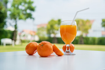 Wall Mural - Orange juice and orange halves on the natural background.