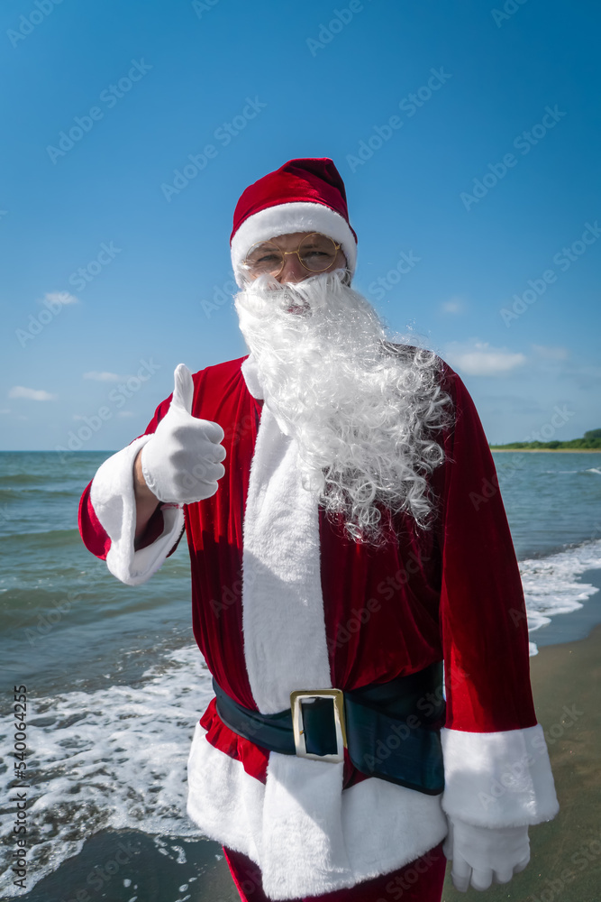 Portrait of Santa Claus with his finger raised up on the sea on a sunny ...