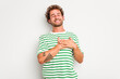 © Asier - Young caucasian curly hair man isolated on white background laughing keeping hands on heart, concept of happiness.