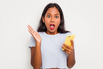 Wall Mural - Young indian woman using mobile phone isolated on white background surprised and shocked.