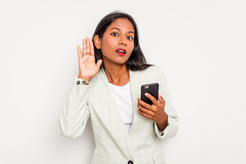 Wall Mural - Young business Indian woman holding a mobile phone isolated on white background trying to listening a gossip.