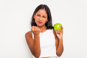 Poster - Young Indian woman holding an apple isolated on white background showing fist to camera, aggressive facial expression.