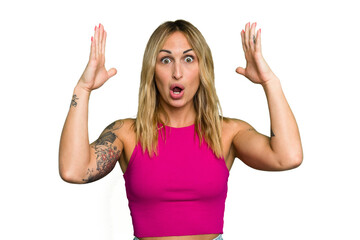 Wall Mural - Young caucasian woman isolated on green chroma background celebrating a victory or success, he is surprised and shocked.