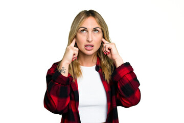 Wall Mural - Young caucasian woman isolated on green chroma background covering ears with fingers, stressed and desperate by a loudly ambient.