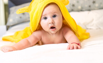 Poster - Baby in a towel after bathing. Selective focus.