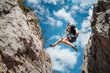 © Soloviova Liudmyla - Climber teenage boy in protective helmet jumping on vertical cliff rock wall using rope Belay device, climbing harness in Paklenica canyon in Croatia. Active extreme sports time spending concept