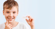 © Татьяна Яблокова - Positive child boy is holding mouth guards for his teeth and smiling. Banner. Invisible braces helps of orthodontics problem. Close-up portrait. Mobile appliance for dental teeth correction.