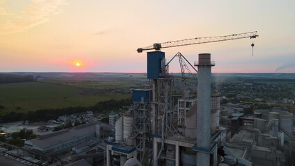 Wall Mural - Aerial view of cement factory with high concrete plant structure and tower crane at industrial production area. Manufacture and global industry concept