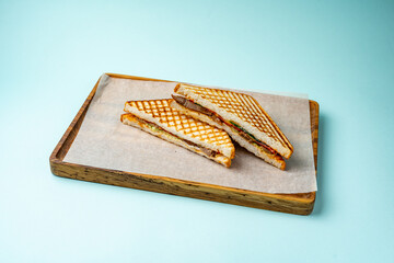 Wall Mural - sandwich with tomato and cucumber on a wooden board on a colored background