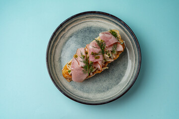 Wall Mural - bruschetta with ham on a plate on a colored background