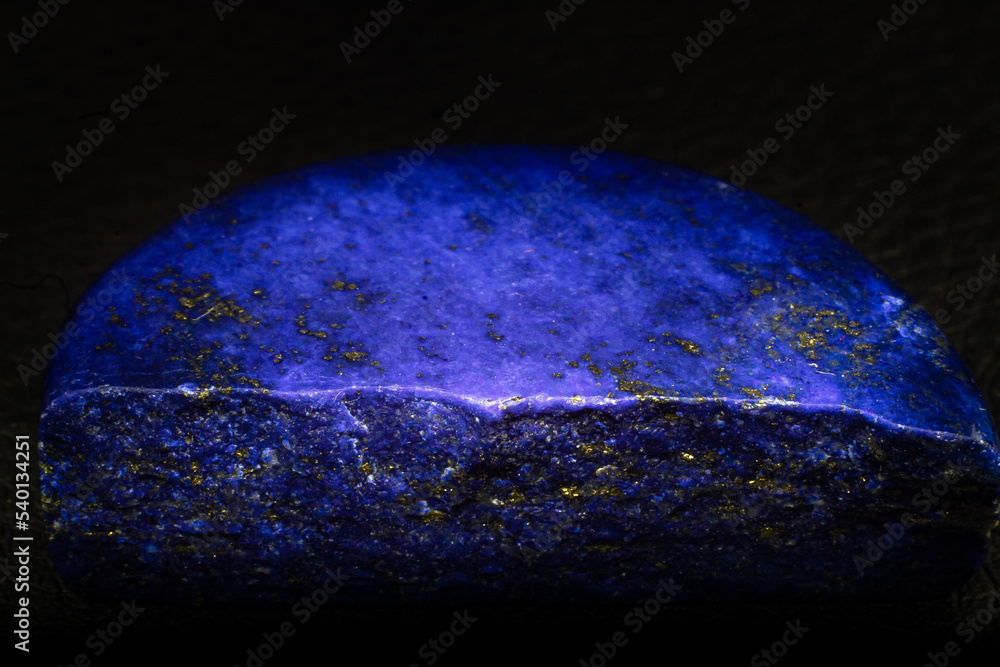 Polished deep blue Lapis lazuli rock macro isolated on black background ...