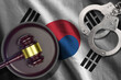 South Korea flag with judge mallet and handcuffs in dark room. Concept of criminal and punishment, background for judgement topics