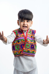 Cute indian little child in ethnic wear and showing expression over white background