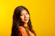 Enlightened positive brunette woman smiling, wears orange t-shirt, has good mood, latina female, closed eyes dreamily, isolated on yellow studio background, mock up space.