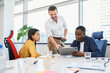 © baranq - Diverse work colleagues discussing project during business meeting at office