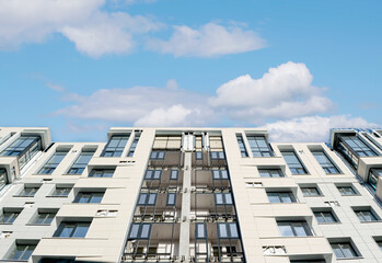 construction of a high-rise residential building against the sky with clouds, bottom view