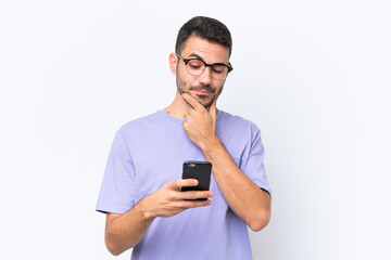 Young caucasian man isolated on white background thinking and sending a message