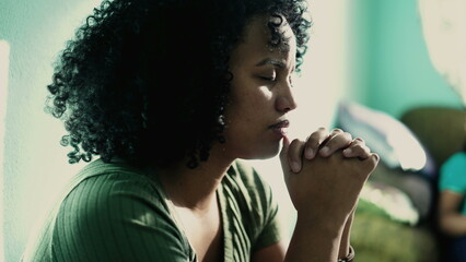 Wall Mural - African American woman praying to God. A spiritual black hispanic girl in prayer having HOPE and FAITH