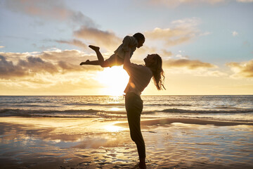 Poster - Mother, girl and sunset silhouette at beach while play, lift and love during summer vacation in Hawaii. Woman, child and energy with fun, carry and care during family travel holiday at Hawaii sea