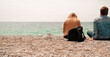 © Ela - man and woman sitting barefoot on sea shore beach