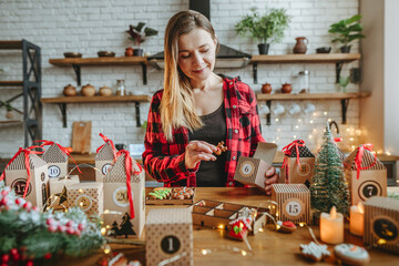 Woman packaging homemade decorated icing Christmas cookies