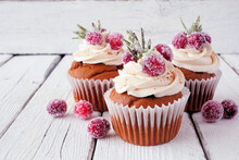 Christmas Gingerbread Cupcakes With Frosty Cranberries. Close Up On A Rustic White Wood Table Background.