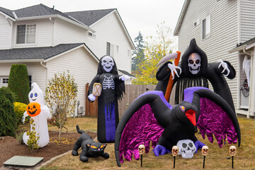 Wall Mural - Halloween outdoor decorations with inflatable ghost, crow, skeleton, death, sculls