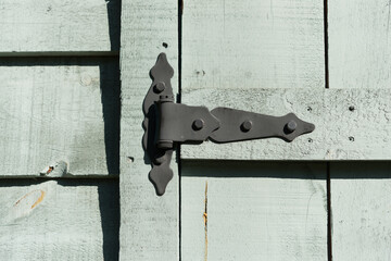 detail of a wood shed and decorative metal hinge