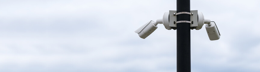 Wall Mural - Outdoor security camera on a pole against the sky. Horizontal photo. Banner