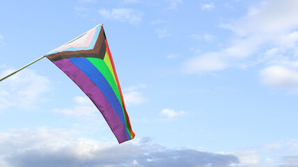 Wall Mural - LGBT rainbow flag waving with blue sky in background to enhance LGBTQ+ community around the world