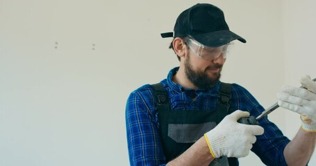 Wall Mural - Builder prepares hand hammer to demolish wall, applies drill, renovates apartment.