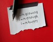 Note stick on red background with handwritten text I AM GROWING I AM ENOUGH I AM HAPPY - positive affirmations self talk practice for daily encouragement and boost self esteem or self worth