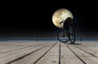 Bicycle by the sea against the backdrop of the full moon at night