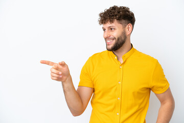 Canvas Print - Young handsome caucasian man isolated on white background pointing finger to the side and presenting a product