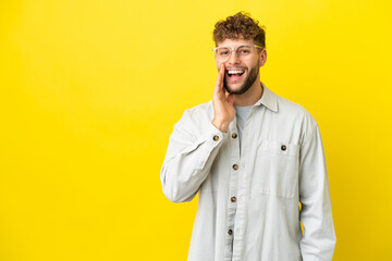 Wall Mural - Young handsome caucasian man isolated on yellow background shouting with mouth wide open