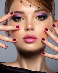 Wall Mural - Portrait of a beautiful woman with bright makeup. Closeup female face with purple eye make-up. Pretty, sexy girl with violet nails near face. Stylish fashion model with a short slick hair