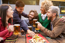 Group Of Friends Enjoying Evening Drinks And Food In Bar. Happy People Laughing. High Quality Photo