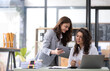 © wichayada - Two young Asian business woman talk, consult, discuss working with new startup project idea presentation analyze plan marketing and investment in the office.
