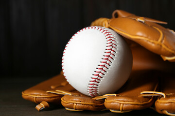 Wall Mural - Leather baseball glove with ball on wooden table, closeup