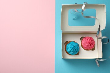 Box with different delicious cupcakes on color background, top view. Space for text