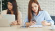 © aFotostock - Two businesswomen team meeting using laptop at company office desk. Two young Female freelance reading financial graph charts Planning analyzing marketing data. Asian people team working office firm.