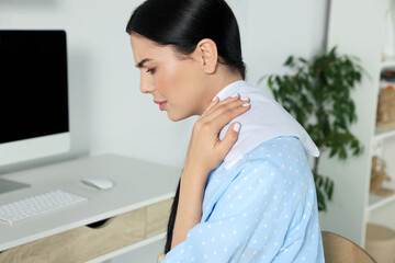 Wall Mural - Young woman using heating pad at home