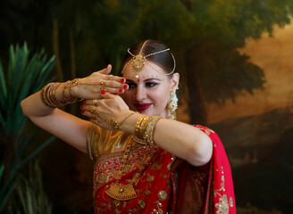 Wall Mural - Beautiful young woman in traditional indian clothing with bridal makeup and jewelry.