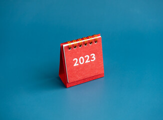 Wall Mural - Merry christmas and happy new year 2023 background. 2023 business year numbers on modern small red desk calendar cover isolated on blue background, minimal style. Ready to start a new goals.