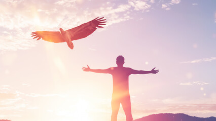 Poster - Man raise hand up on top of mountain and sunset sky with eagle birds fly abstract background.