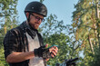 © perfectlab - Young male biker in helmet using mobile phone and smiling sitting on a motorcycle