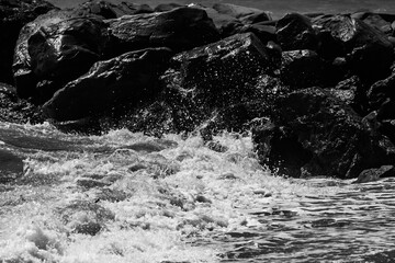 Poster - sea waves with foam and large stones. black and white beach photography